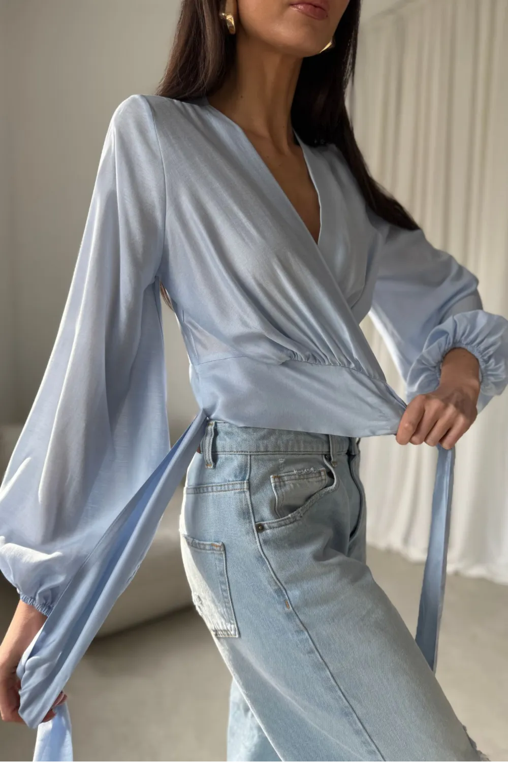 Nerina – kopertowa bluzka wiązana w talii, długi rękaw, błękitna | Roco Fashion