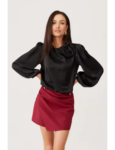 Evelyn – czarna satynowa bluzka z ozdobnym kwiatem na ramieniu i bufiastymi rękawami | Roco Fashion
